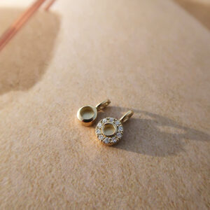 Deze bedel van het merk Minioro is vervaardigd uit 14 karaats goud en heeft een grotere hanger waarin een vingerafdruk, as of moedermelk verwerkt kan worden. Zo ontstaat een elegant en persoonlijk aandenken vol betekenis, afgewerkt met schitterende diamanten.